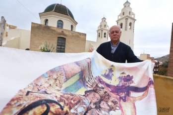 Ramón González muestra un cobertor con la imagen de los Santos Patronos.