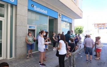 La gente hace largas colas para sus gestiones en el único cajero automático de la entidad bancaria en Petrer.