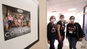 Usuarias de AcMAVI posan junto a la portada de la exposición.
