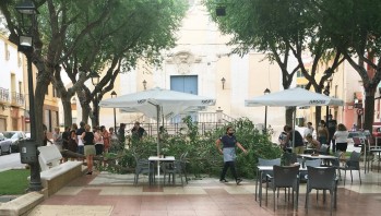 Una rama cae en la Plaza de Baix de Petrer junto a las mesas de un bar